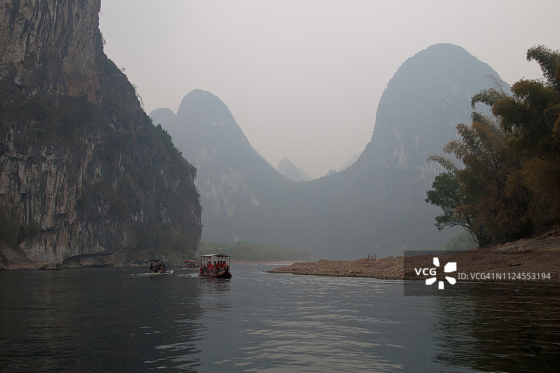 中国桂林，乌云笼罩下漓江上的石灰岩喀斯特山图片素材
