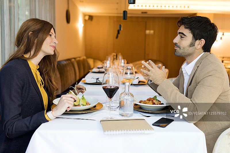 微笑的男人和女人在餐馆吃饭图片素材