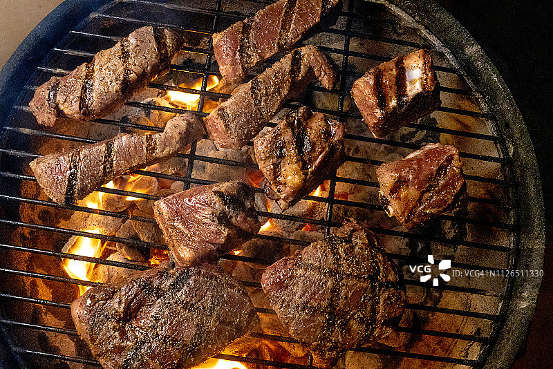 火烤架上的无骨牛肉和带骨排骨烧烤酱图片素材