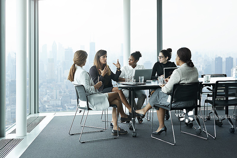 一群女商人在会议室开会，窗外是美丽的天际线图片素材