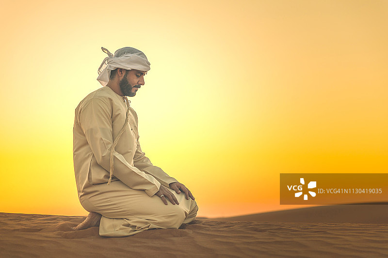 在沙丘上做晚祷的阿拉伯人图片素材