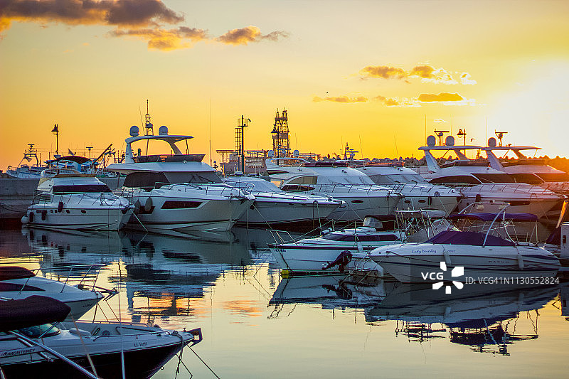 利马索尔，塞浦路斯，2018年12、28日:利马索尔码头从游艇到游艇再到渔船，日出时风景如画的码头在金色的天空下平静，一天开始。图片素材