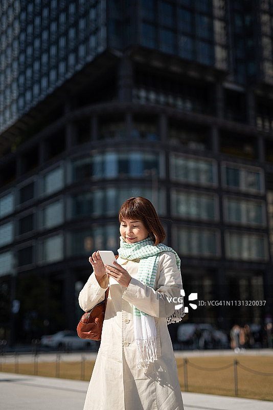 女商人在街上看智能手机图片素材