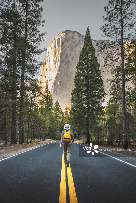美国加利福尼亚州约塞米蒂国家公园，一名男子走在路上，背景是酋长岩图片素材