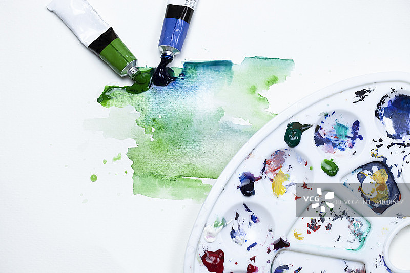 在纸上混合水彩颜料，用颜料从颜料管中流出来创造水彩效果。图片素材