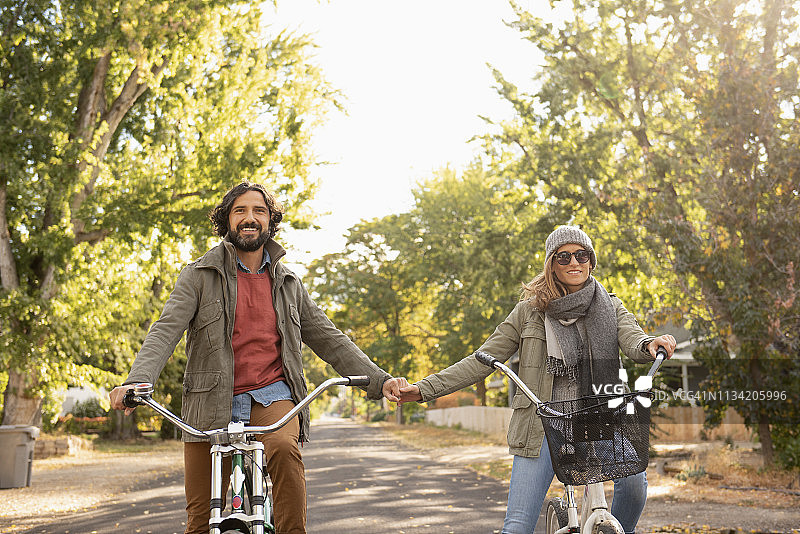 在郊区大街上骑自行车的夫妇图片素材