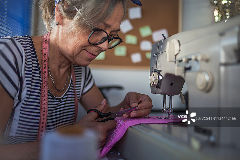 在家里用缝纫机干活的妇女图片素材