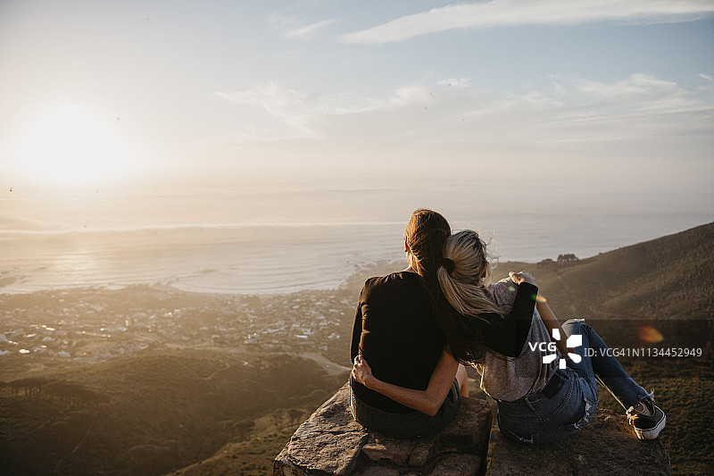 南非，开普敦，克卢夫·奈克，日落时分坐在岩石上的两名妇女图片素材