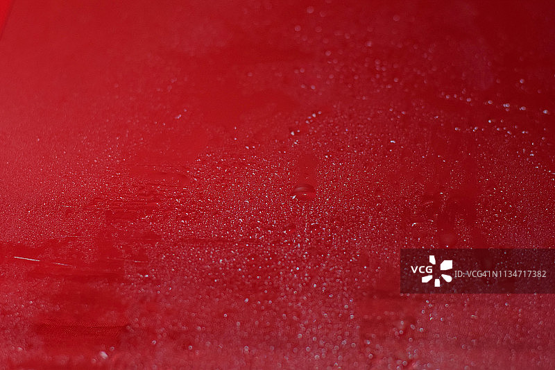 水滴靠近。抽象的红色背景的水滴，水滴。图片素材