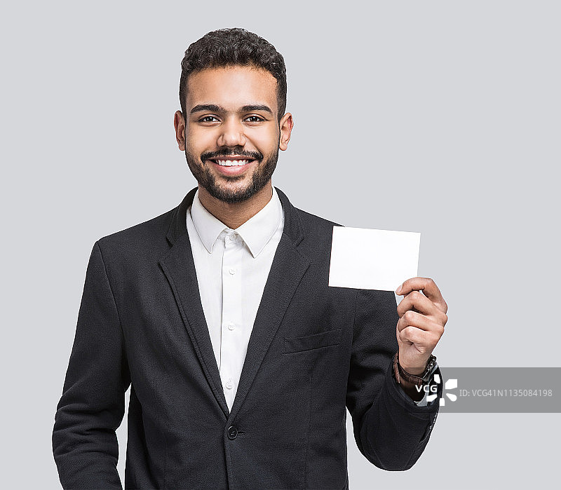 英俊的微笑男子的肖像显示空白的白色卡片图片素材