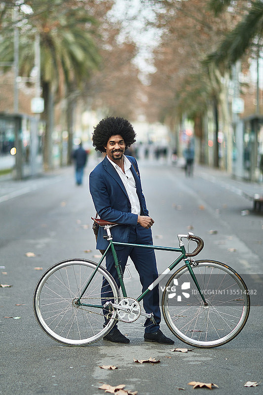 在城市里靠在自行车上的商人的肖像图片素材