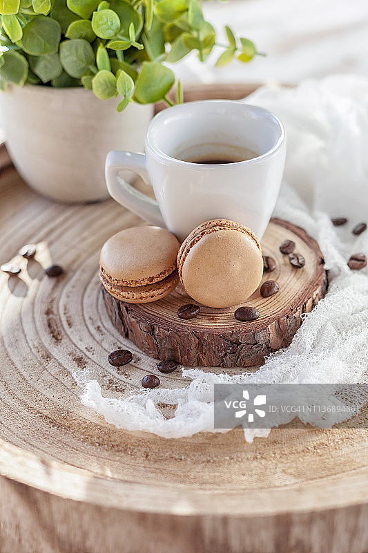 法式马卡龙和一杯用木托盘盛着的黑咖啡图片素材