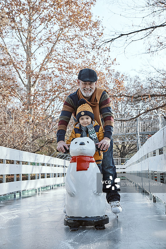 爷爷和孙子在溜冰场上滑冰，用北极熊的身影作为道具图片素材
