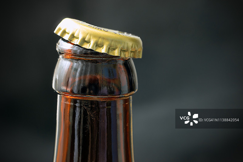一瓶啤酒打开了一个黑暗的背景特写图片素材