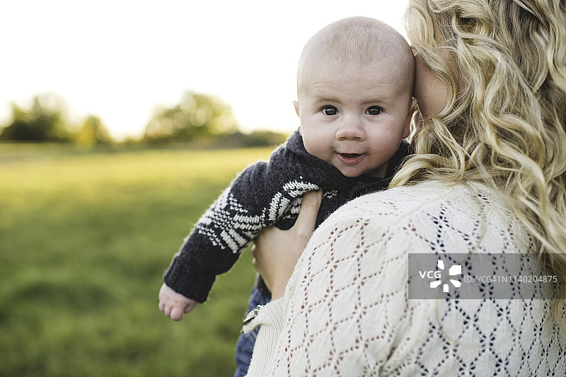 婴儿的肖像在母亲的怀里在田野图片素材