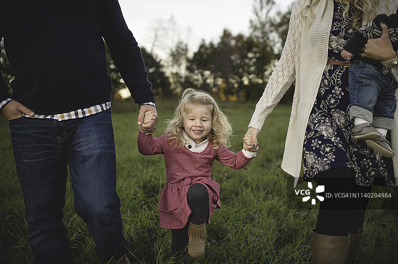这是一对中年夫妇带着女儿和男婴散步的剪影图片素材