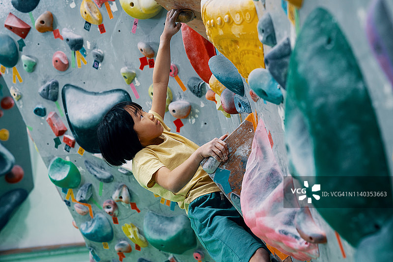 一个小女孩正在攀岩馆攀岩图片素材