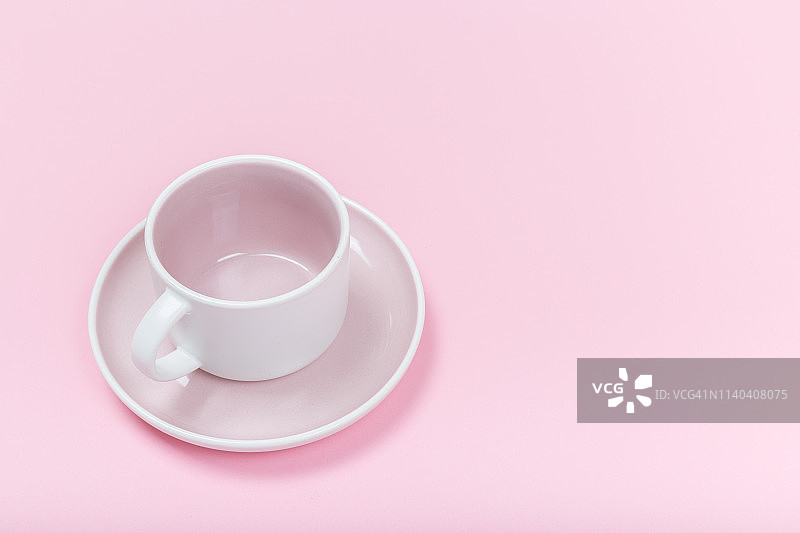 粉红色背景上的陶瓷咖啡杯图片素材