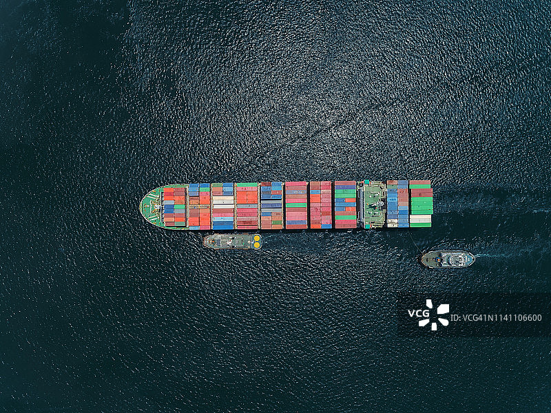 鸟瞰图拖船和集装箱船满载集装箱在深海物流，进出口，航运或运输。图片素材