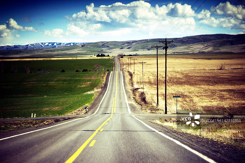 美国西部贯穿农业景观的乡村公路图片素材