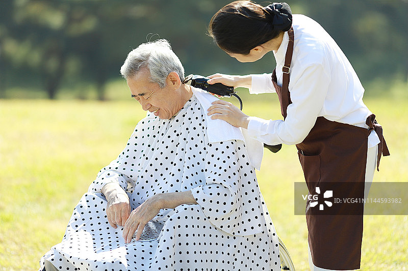 发型师用剪子为老年人理发图片素材