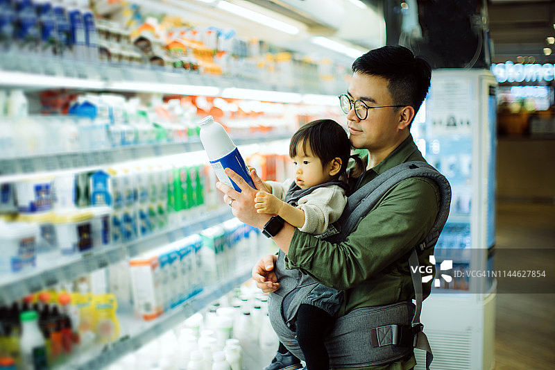 年轻的亚洲父亲和可爱的小女儿在超市购买乳制品图片素材