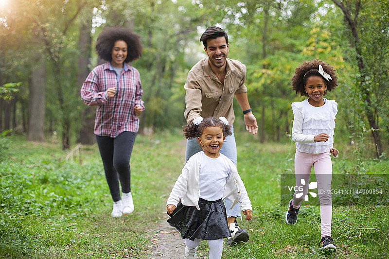 无忧无虑的家庭有乐趣，而在春日户外跑步。图片素材