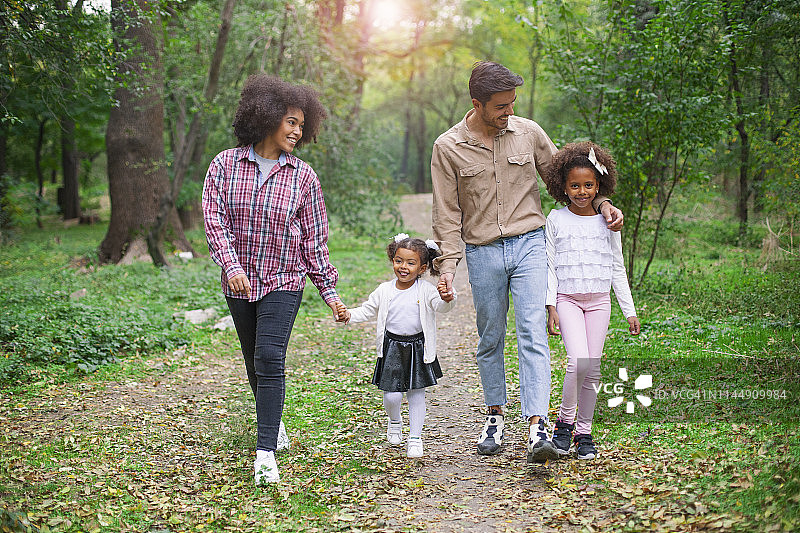 幸福的一家人在树林里的小路上散步图片素材