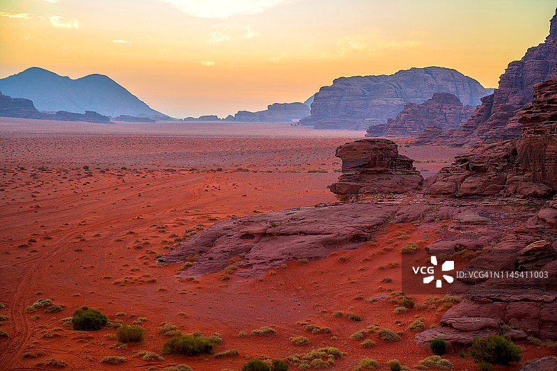 约旦瓦迪拉姆沙漠的红色沙丘和神奇岩石的日出景象图片素材