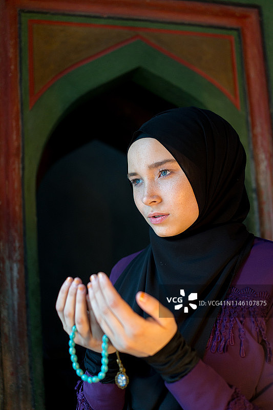 一个穆斯林女孩正在清真寺里祈祷图片素材