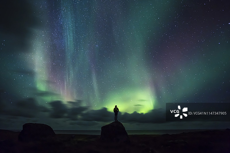 挪威，罗浮敦群岛，艾格姆，人们站在岩石上观看北极光图片素材