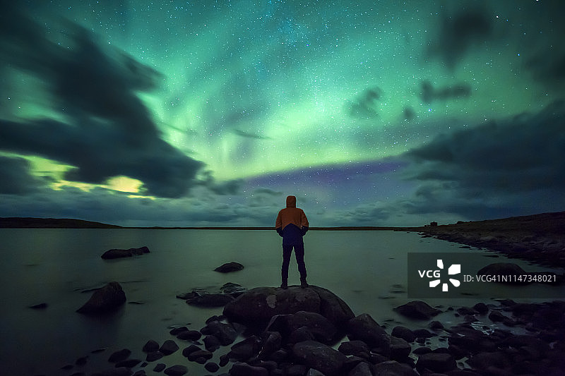 挪威，罗浮敦群岛，埃格姆，一个崇尚北极光的年轻人图片素材
