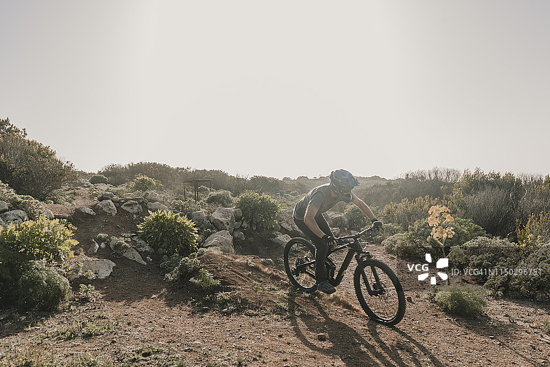 西班牙，兰萨罗特，在沙漠中骑行的登山运动员图片素材