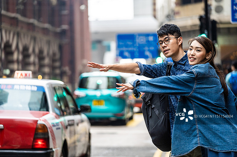 有两个人在香港试图打出租车。图片素材