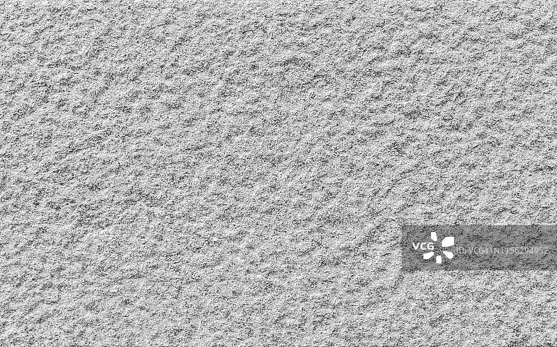 一个凹凸不平的花岗岩石墙的特写，黑白相间。高分辨率全帧背景纹理。图片素材
