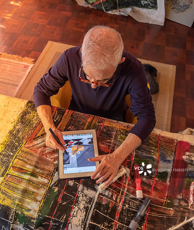 艺术家中年男子在画布上以数字方式绘画图片素材