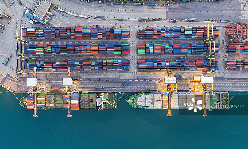 鸟瞰港口集装箱船，工作起重机桥装集装箱用于物流，进出口，运输或运输。图片素材