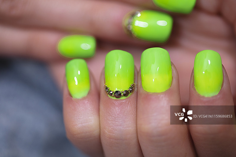 特写的女人的手指与指甲艺术美甲在霓虹灯绿色图片素材