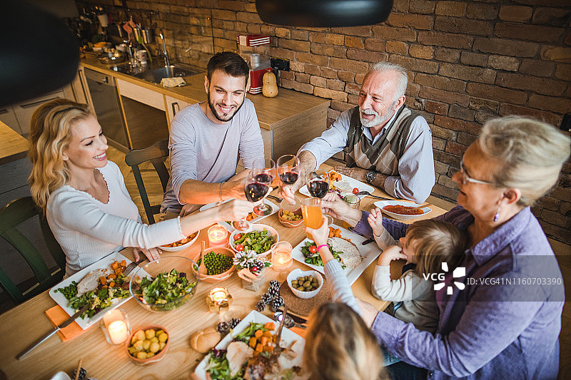 上图是在餐厅举行的感恩节晚宴上一家人举杯庆祝的情景。图片素材