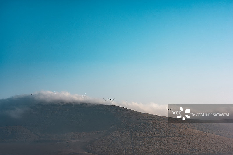 风力涡轮机在晨雾山顶图片素材