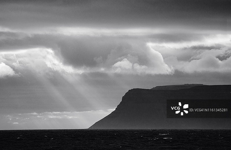 冰岛西峡湾海岸线上的黑色和白色的戏剧性阳光图片素材