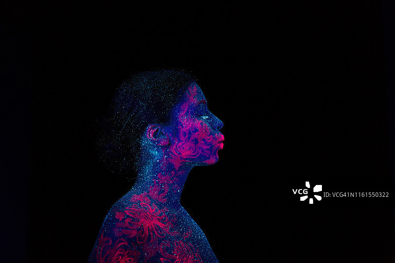 一个美丽的女孩外星人的侧面肖像。紫外线人体艺术，蓝色的夜空，星星和粉红色的水母，图片素材