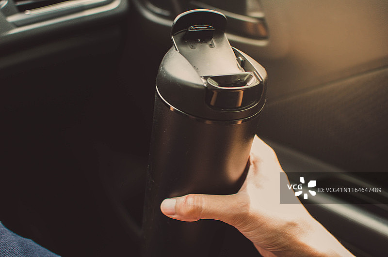 在车里用可重复使用的咖啡杯喝热咖啡图片素材