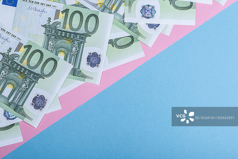 蓝色和粉色背景的欧元现金。欧元纸币。欧元的钱。欧元的法案。文本。图片素材