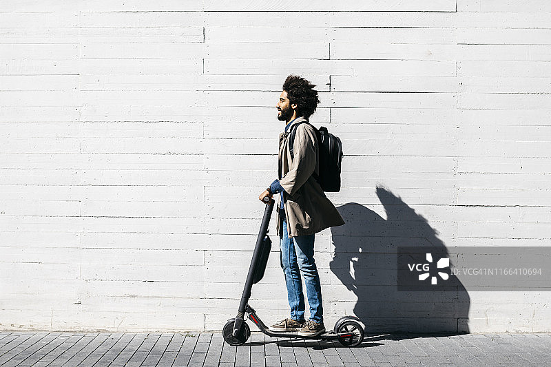 背着电动滑板车背包的男人图片素材