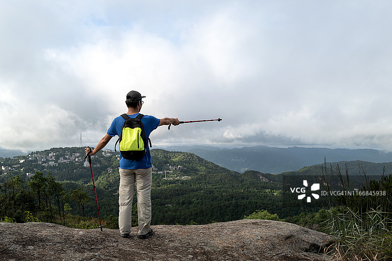 年轻男性登山户外在山上眺望远方图片素材