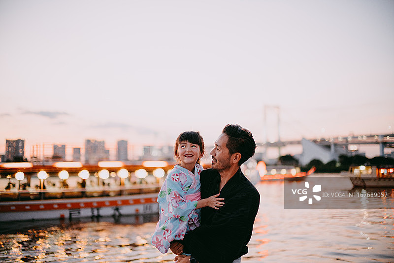 日本父亲和学龄前的女儿穿着和服在船上，东京图片素材