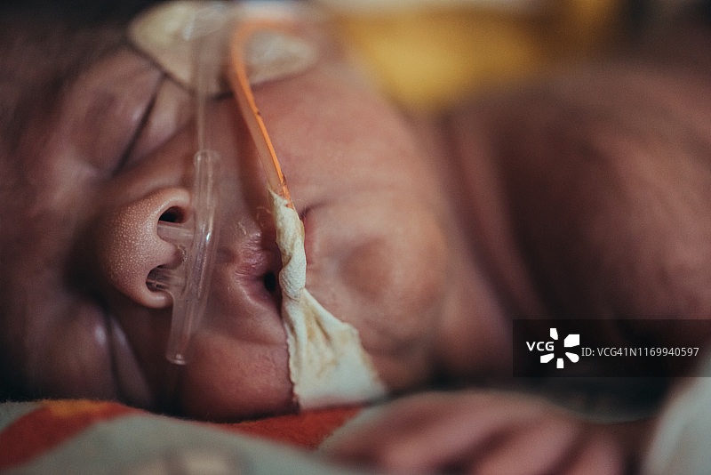 早产儿在新生儿重症监护室中睡眠的特写/微距观察图片素材