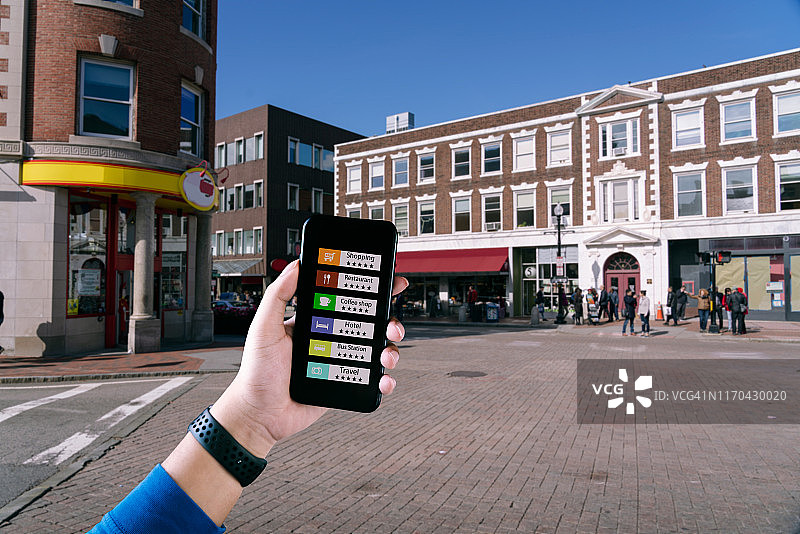 手持平板使用AR应用程序检查客户周围空间的相关信息。城市背景。图片素材