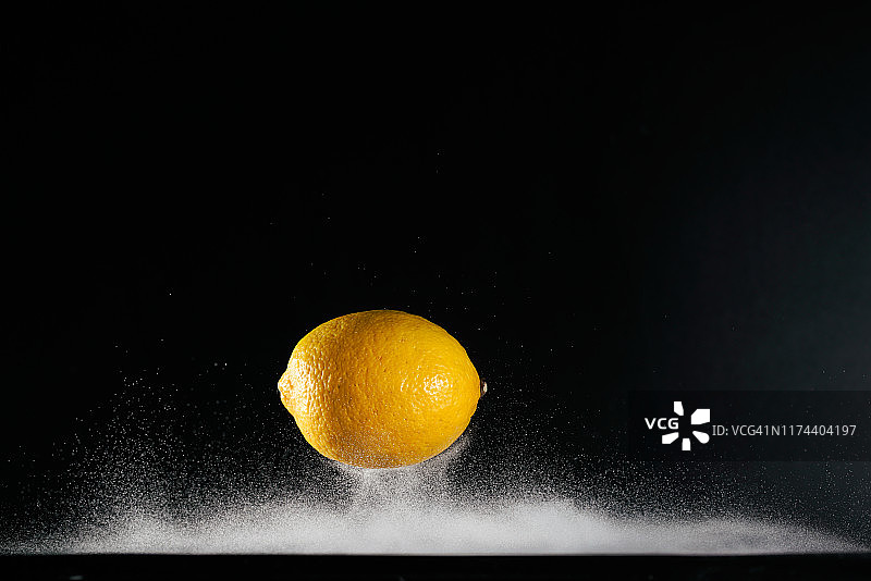 黄色柠檬在半空中飞行与水捕获高速图片素材